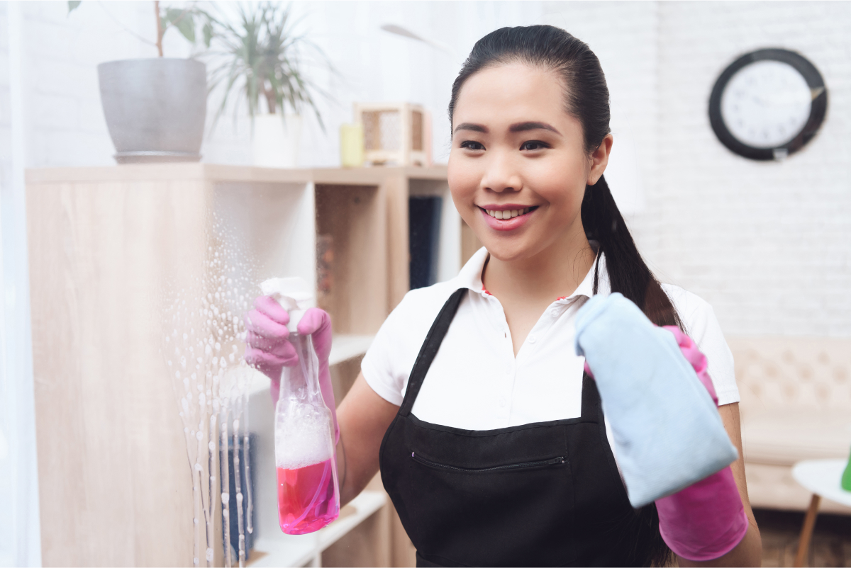 smiling-asian-housemaid-washes-window-with-cloth